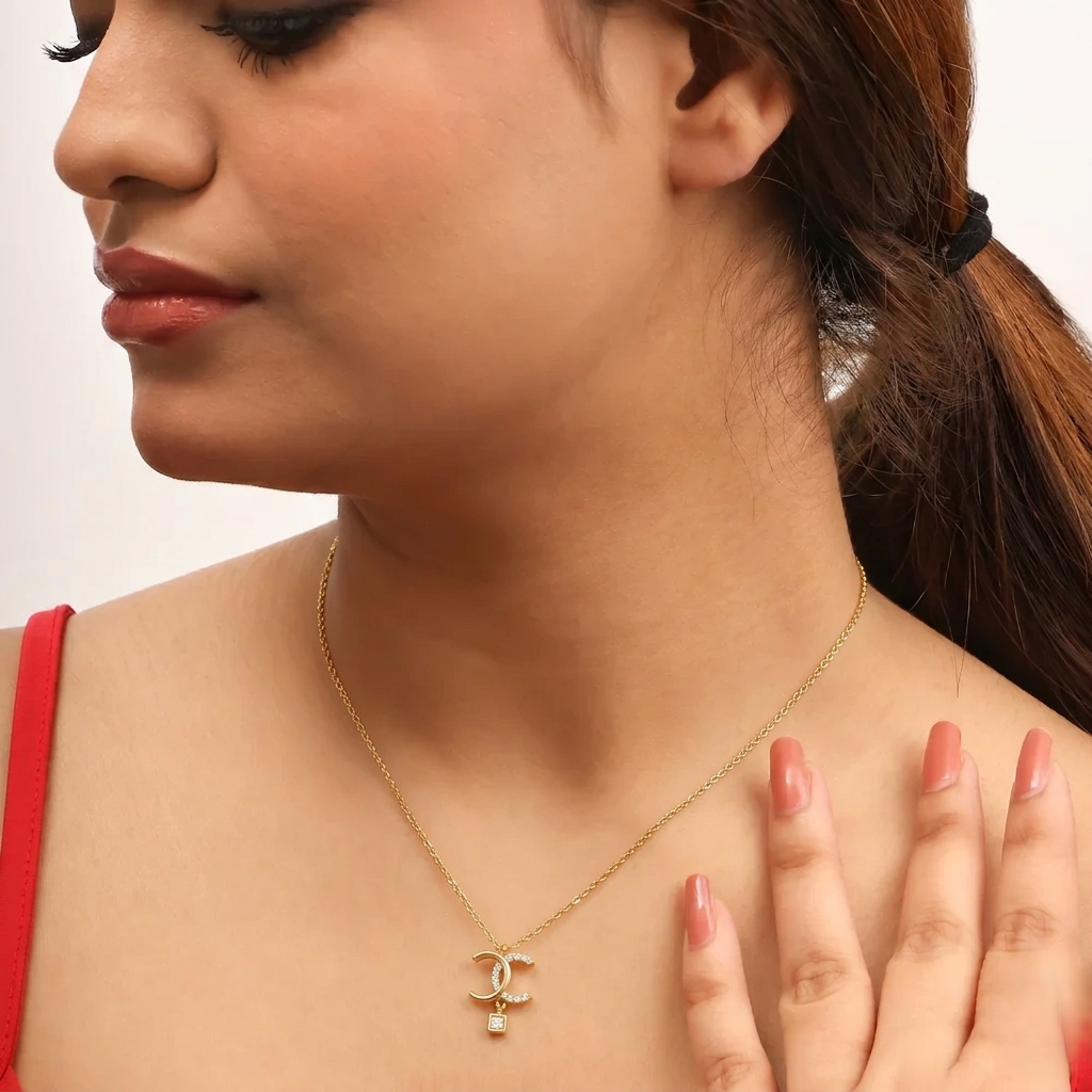 Close-up of a woman wearing a gold necklace with a pendant on a plain background
